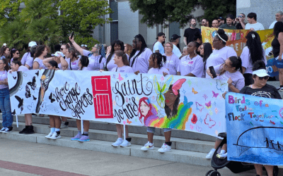 a crowd of people on some steps, holding recovery banners