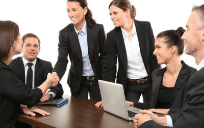 a group of people in business suits talking over a table