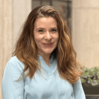 a white woman with light brown shoulder-length hair, wearing a seafoam green shirt