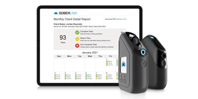 a photo of a tablet screen, with SoberLink showing a report; two devices are on the right of the screen