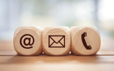 three wooden blocks; the first has the @ symbol, the second has the icon for email, and the third has the icon for phone
