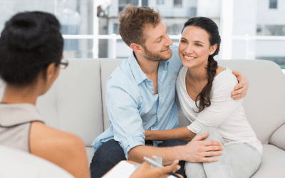 a man and woman on the couch, with a woman talking to them